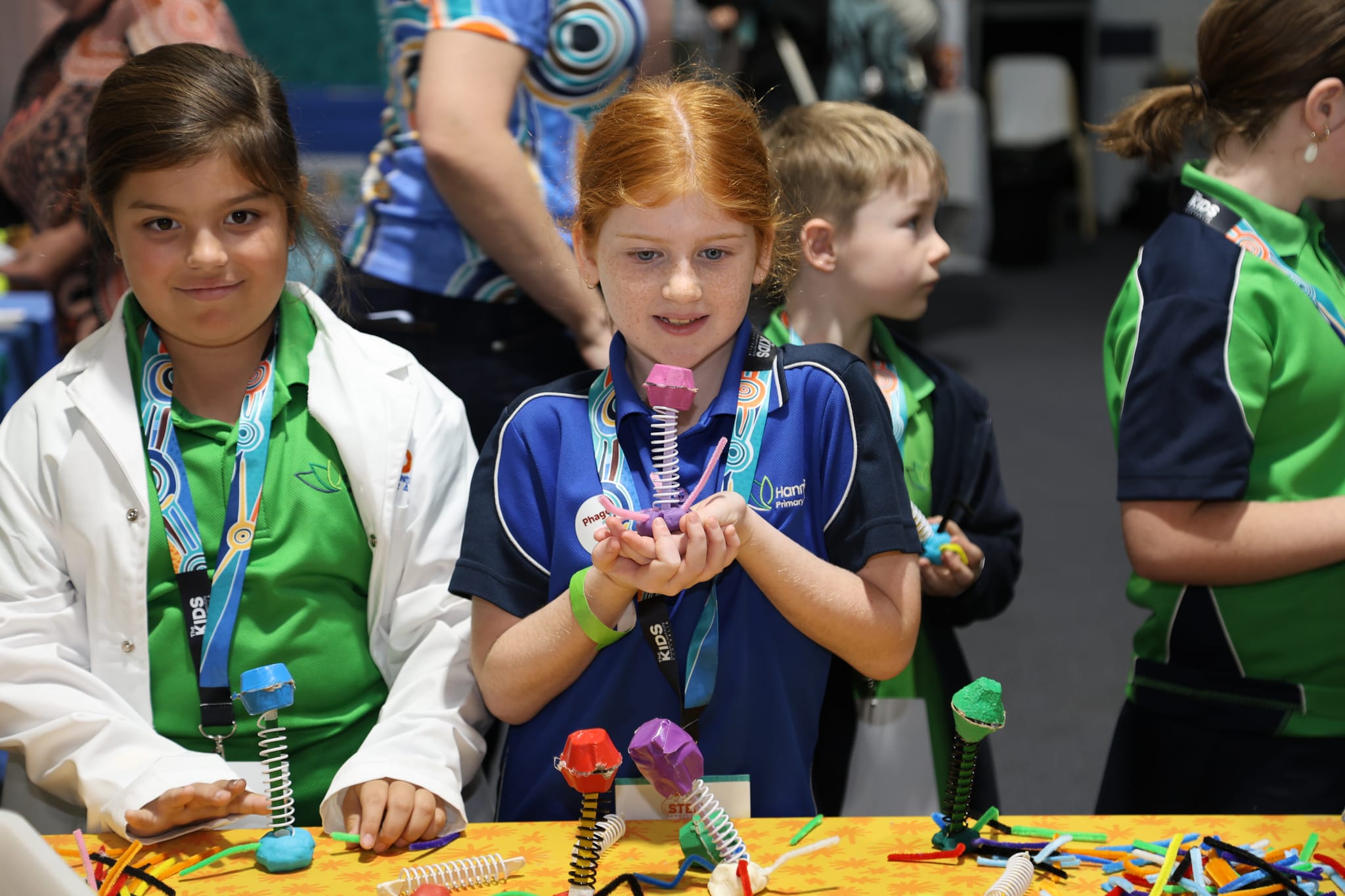 Kids holding up art models of bacteriophages